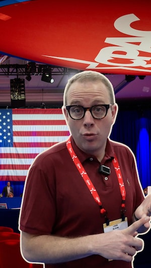 Il s'agit d'un montage de deux photos. Devant, une photo du correspondant de Radio-Canada aux États-Unis, Louis Blouin. Il porte des lunettes et une chemise rouge. Derrière, la scène de la conférence conservatrice. On voit un gros logo rouge au plafond, il est écrit CPAC en blanc.