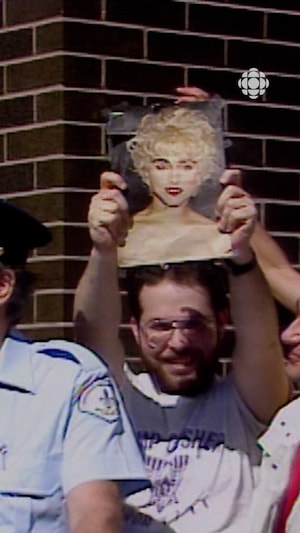 Un homme tien une photographie de Madonna en attendant en ligne pour des billets de spectacle devant le forum de Montréal. 