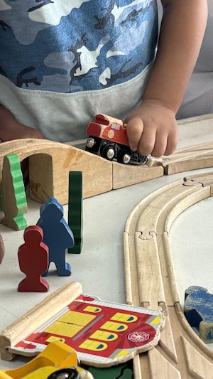 Des mains d'enfants jouant avec des jouets, des petites voitures et des figurines.