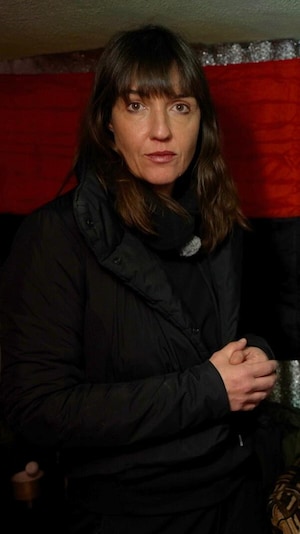 Marie-Eve est debout, derrière deux soldats qui sont assis devant des écrans. Le plafond est très bas et l'espace est restreint.  