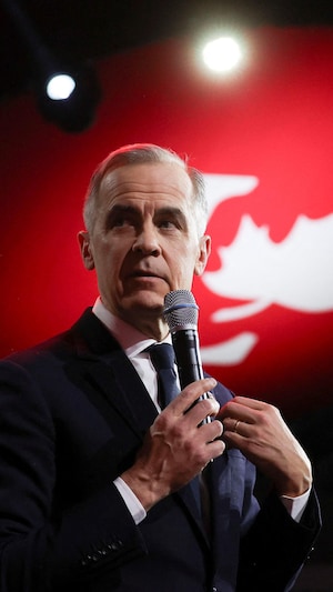 Mark Carney dans un micro sur scène.