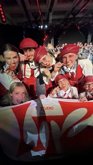 Les danseurs de Maze croquent dans une médaille de bronze avec leur entraîneuse. 