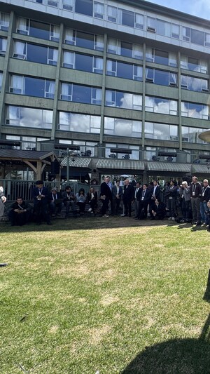 Des membres des médias attendent le début d'une conférence de presse à l'extérieur de l'hôtel Rimrock à Banff.