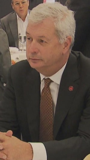 Michael Rousseau assis à une table lors d'un événement d'affaires.