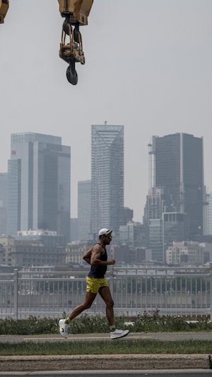 Une personne fait son jogging devant le panorama urbain de Montréal, Québec, Canada, le 6 juin 2025.