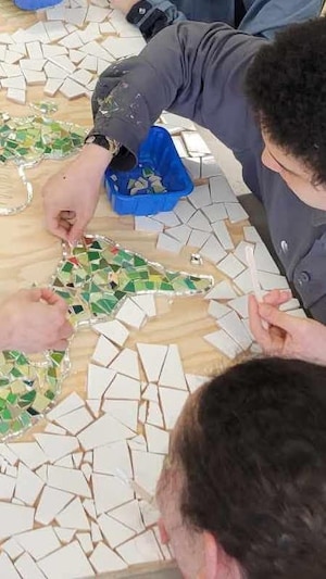 Des personnes réalisent une mosaïque.