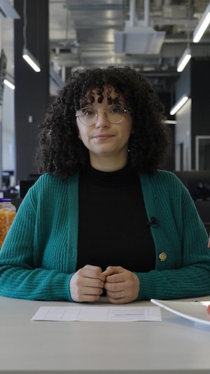 La journaliste Nahila Bendali est debout devant une table haute