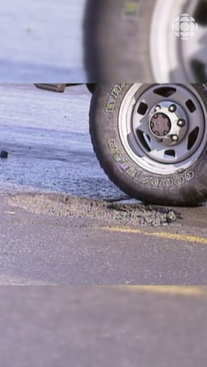Roue de voiture qui évite un trou sur la chaussée.