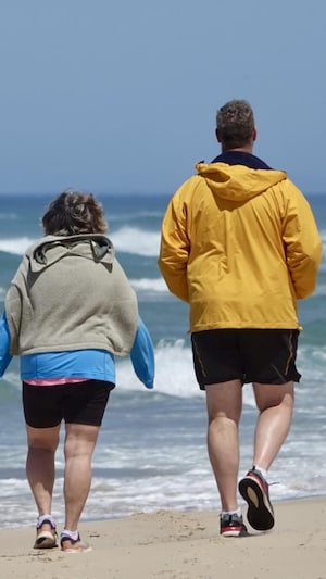 Deux personnes marchent sur la plage de Pointe-aux-Loups.                       