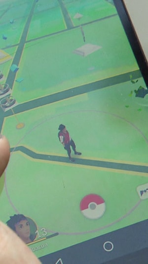 Gros plan d'un téléphone d'un joueur en train de jouer à Pokémon GO.