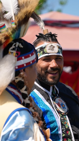 Deux danseurs du pow-wow se regardent en souriant.