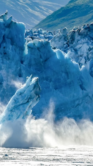 Des morceaux d'un glacier se détachent et tombent dans la mer.