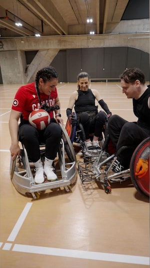 Trois personnes jouent au rugby en fauteuil roulant.