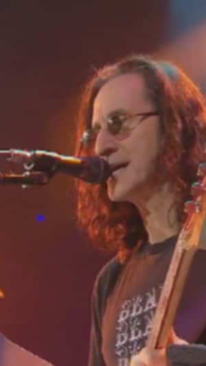 Geddy Lee pendant une performance musicale. 