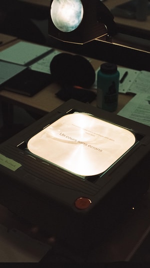 Un rétroprojecteur sur lequel est inscrit « Cours sans écrans ». 