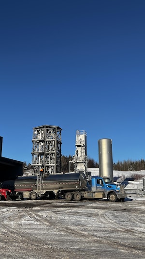 Une usine avec un camion-citerne stationné.