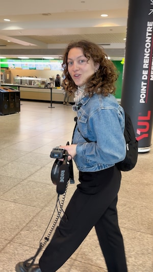 La journaliste Emma Guerrero Dufour marche dans le hall d'un aéroport.