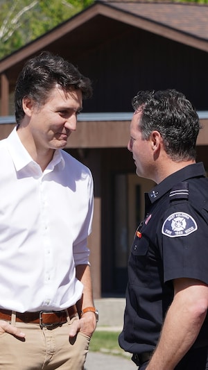 Le premier ministre Justin Trudeau avec des pompiers à Kelowna, le 10 mai 2024.