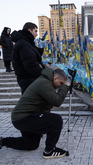 Des personnes rendent hommage aux soldats morts au combat en Ukraine, sur la place Maïdan où des milliers de drapeaux commémoratifs sont exposés pour rappeler le bilan de la guerre, le 24 février 2025.