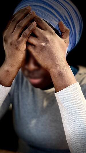 Une femme prend sa tête entre ses mains.