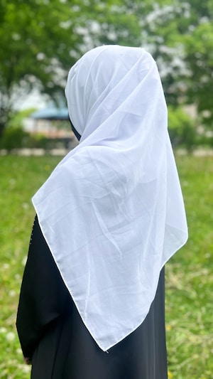 Une jeune femme de dos, portant un voile intégral.
