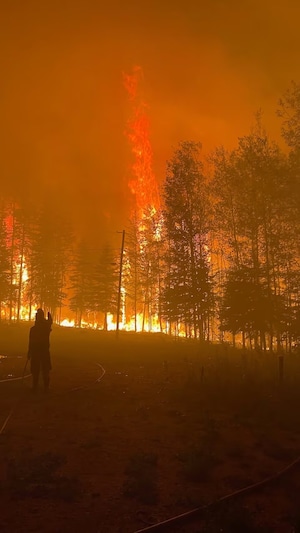 Un homme tente de freiner le feu autour de lui.