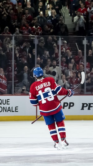 Un joueur de hockey regarde la foule qui célèbre son but. 