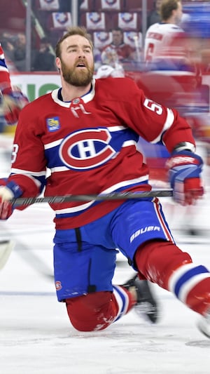 Il s'étire, un genou sur la glace, au milieu de ses coéquipiers.