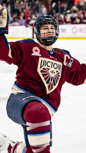 Elle lève les bras avec le genou gauche sur la glace.