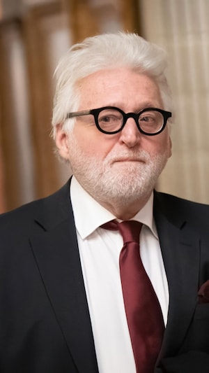 Gilbert Rozon marchant dans les couloirs du palais de justice de Montréal, l'air sérieux.