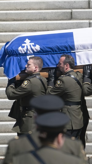 Des policiers transportant un cercueil.