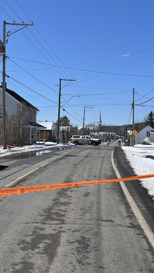 Un ruban orange de la Sûreté du Québec bloque l'accès à la rue Laurent Thibeault à Sainte-Angèle-de-Mérici. 