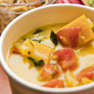La soupe de courge parfumée à l’indienne de Caroline Dumas servie dans un bol en carton pour emporter.