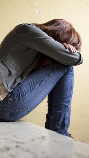 Une adolescente dans un escalier.