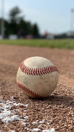 Une balle de baseball repose sur un terrain. 