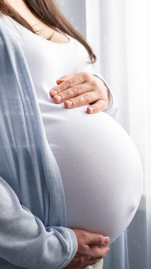 La femme enceinte se tient le ventre.