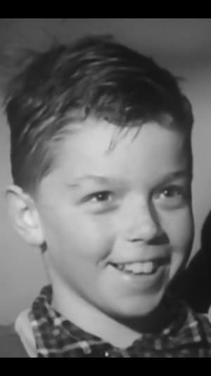 Un jeune garçon sourit lors d'une entrevue à la télévision.
