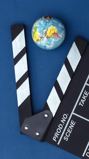 Une claquette de cinéma aux côtés d'une balle aux couleurs de la Terre.
