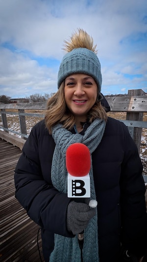 Emmanuelle Robinson tient un microphone.