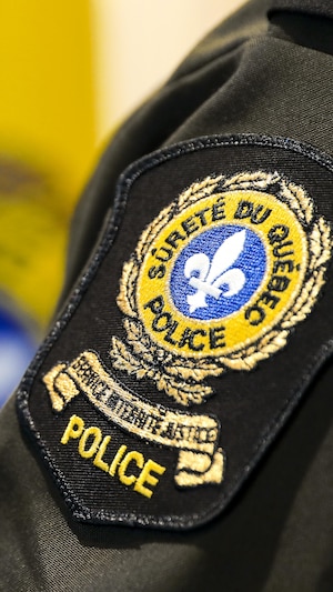 Un écusson de la Sûreté du Québec sur le bras d'un policier.