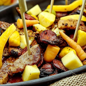Assiette avec des morceaux de viandes, des fruits et des légumes.
