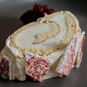 Un morceau de bûche de Noël, chaï et agrumes, servie avec une compote de canneberges