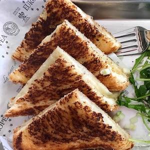 Un grilled cheese accompagné d'une salade.