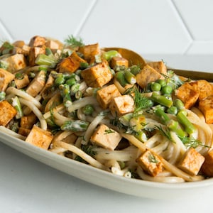 Une salade de pâtes aux légumes verts et tofu barbecue.