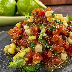 La salsa est composée de tomates, de maïs en grains et d'herbes fraîches