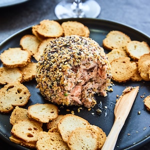 Une boulette de saumon fumé est au centre d'une assiette entourée de chips de bagel.