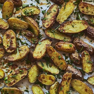 Des demies pommes de terre disposées sur une plaque de cuisson.