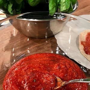 De la sauce tomate avec une cuillère.