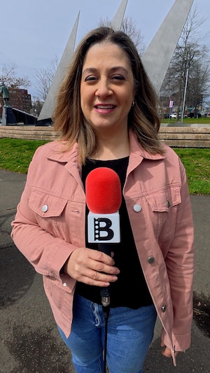 Emmanuelle Robinson tient un microphone.