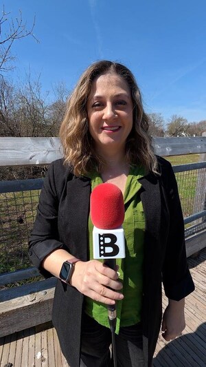 Emmanuelle Robinson tient un microphone.